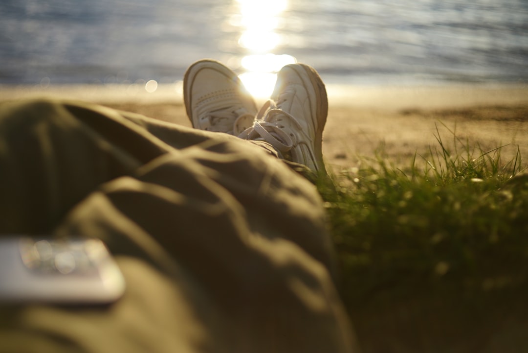 Person relaxing by the water at sunset