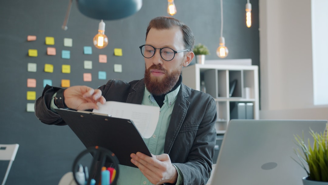 Man in glasses reviewing documents at desk