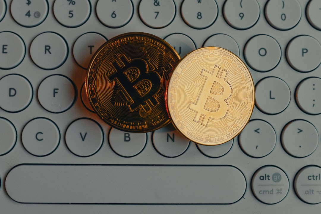 a bit coin sitting on top of a computer keyboard