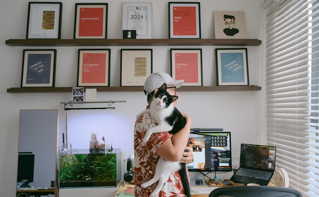 Person holding a cat in an office setting